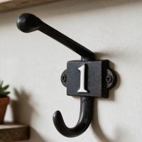 The Iron Coat Hook with the Number 1 Painted on it Shown Mounted on a Wall in a Modern Home - Digital Illustration The Iron Coat Hook with the Number 1 Painted on it Shown Mounted on a Wall in a Modern Home - Digital Illustration
