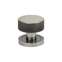 The Knurled Mortice/Rim Knob Set on a Plain Rose in Pewter Shown Upright on a White Background The Knurled Mortice/Rim Knob Set on a Plain Rose in Pewter Shown Upright on a White Background