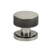 The Knurled Mortice/Rim Knob Set on an Art Deco Rose in Pewter Shown Upright on a White Background The Knurled Mortice/Rim Knob Set on an Art Deco Rose in Pewter Shown Upright on a White Background