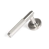 The Knurled Sprung Handle Set on a Round Rose in Satin Stainless Steel Shown at an Angle on a White Background