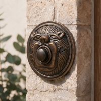 The “Lambeth Hall” Burnished Copper Round Lion Bell Push on a Granite Stone Wall next to a Wooden Front Door - Digital Illustration The “Lambeth Hall” Burnished Copper Round Lion Bell Push on a Granite Stone Wall next to a Wooden Front Door - Digital Illustration