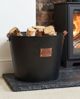 The Large "Logs" Black Log Basket Seen Placed on a Stone Hearth in a Modern Home next to a Log Burner - Digital Illustration The Large "Logs" Black Log Basket Seen Placed on a Stone Hearth in a Modern Home next to a Log Burner - Digital Illustration