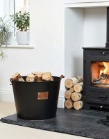 The Large "Logs" Black Log Basket Seen Placed on a Stone Hearth in a Modern Home next to a Log Burner - Digital Illustration The Large "Logs" Black Log Basket Seen Placed on a Stone Hearth in a Modern Home next to a Log Burner - Digital Illustration