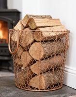 The Large Rose Gold Wire Log Basket on a Stone Hearth next to a Traditional Lob Burner Stove - Digital Illustration The Large Rose Gold Wire Log Basket on a Stone Hearth next to a Traditional Lob Burner Stove - Digital Illustration