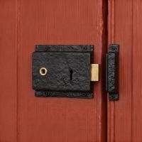 The Left Handed "Almerry" Black Iron Rim Lock on an Orange Door to a Country Home - Digital Illustration The Left Handed "Almerry" Black Iron Rim Lock on an Orange Door to a Country Home - Digital Illustration