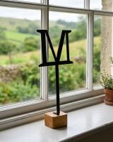 The Letter "M" Monograph Metal & Wood Letter Display Ornament Shown next to a Window in a Country Home - Digital Illustration 