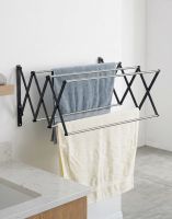 The Lindham Spacesaving Foldaway Towel Rack Mounted on a Wall Next to a Bath - Digital Illustration