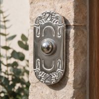 The "Mackintosh" Bright Chrome Ornate Bell on a Sunny Home Wall next to a Front Door - Digital Illustration
