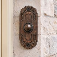 The "Mackintosh" Burnished Copper Ornate Bell Pushes on a White Stone Wall in Front of a Country Home - Digital Illustration The "Mackintosh" Burnished Copper Ornate Bell Pushes on a White Stone Wall in Front of a Country Home - Digital Illustration