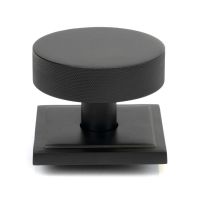 The Matt Black Knurled Centre Door Knob on a Square Rose Shown Upright on a White Background 