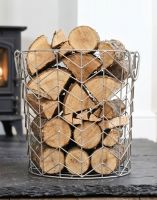 The Medium Pewter Finish Wire Work Log Basket Filled with Logs in Front of a Traditional Log Burner Stove - Digital Illustration The Medium Pewter Finish Wire Work Log Basket Filled with Logs in Front of a Traditional Log Burner Stove - Digital Illustration