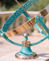 The Medium Size Profatius Armillary Verdigris on a Square Pillar on a Garden Wall with a Patio Behind Close up of the Base - Digital Illustration