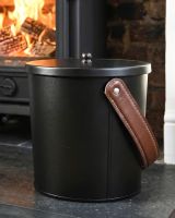 The Modern Black With Leather Handle Ash Bucket Displayed with an Upright Brown Handle in Front of a Decorative Fireplace - Digital Illustration The Modern Black With Leather Handle Ash Bucket Displayed with an Upright Brown Handle in Front of a Decorative Fireplace - Digital Illustration