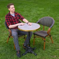 The Monaco Parisian Bistro Set in Black and Grey With a Man Sat on one of the Chairs