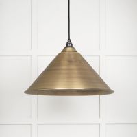 The Nidus Pendant Light in Aged Brass on a White Panelled Background with Light off