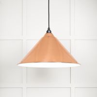 The Nidus Pendant Light in Copper and Glossy White on a White Panelled Background with Light on
