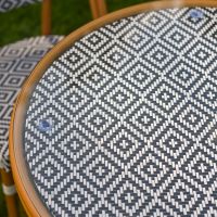 The Orbis Diamond 4-Seater Bistro Dining Set in Black & White Showing a Close up of the Glass Top Table