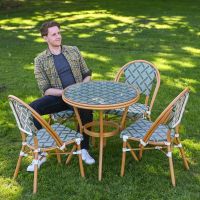 The Orbis Diamond 4-Seater Bistro Dining Set in Green & White With a Man Sat down on a Chair on a Garden lawn