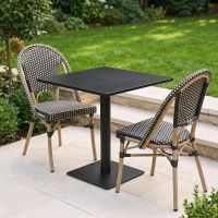 The Parisienne Bistro 2 Seater Outdoor Dining Set in Black and White Shown in a Sunny Low Walled Garden - Digital Illustration
