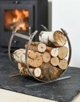 The Pewter Blacksmith Curved Log Rack with Logs Stacked on it next to a Black Log Burner Stove - Digital Illustration