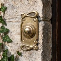 The Polished Brass "Art Nouveau" Door Bell Push next to a Wooden oor Frame on a Stone Wall - Digital Illustration The Polished Brass "Art Nouveau" Door Bell Push next to a Wooden oor Frame on a Stone Wall - Digital Illustration
