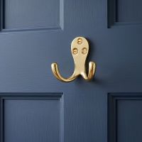 The Polished Brass Double Pronged Coat Hook on the Back of a Blue Interior Door - Digital Illustration The Polished Brass Double Pronged Coat Hook on the Back of a Blue Interior Door - Digital Illustration