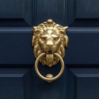 The Polished Brass Lion Head Door Knocker on a Blue Door at the Front of a Home - Digital Illustration The Polished Brass Lion Head Door Knocker on a Blue Door at the Front of a Home - Digital Illustration