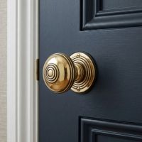 The Polished Brass Ridged Door Knob Set on a Classic Blue Door with a White Frame - Digital Illustration The Polished Brass Ridged Door Knob Set on a Classic Blue Door with a White Frame - Digital Illustration
