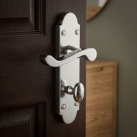 The Polished Chrome Arched Backplate Bathroom Door Handle on a Dark Wooden Door in a Contemporary Home - Digital Illustration