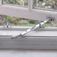 The Polished Chrome Georgian Reeded Casement Window Stay Fitted on a White Window Frame in a Country Home - Digital Illustration The Polished Chrome Georgian Reeded Casement Window Stay Fitted on a White Window Frame in a Country Home - Digital Illustration