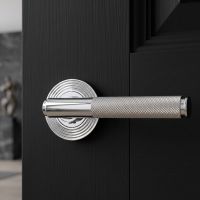 The Polished Chrome Knurled Lever on Beehive Rose Set on a Black Door Shown up Close in a Country Home - Digital Illustration