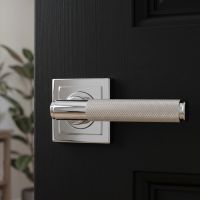 The Polished Chrome Knurled Lever on Square Rose Set Shown up Close on a Black Door in a Country Home - Digital Illustration