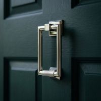 The Polished Chrome Modern Knurled Rectangular Door Knocker Mounted on a Green Door on a Modern Home - Digital Illustration