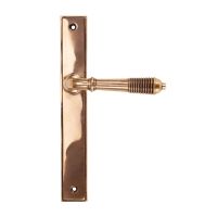 The Reeded Slimline Lever Espagnolette Door Latch in Polished Bronze on a White Background The Reeded Slimline Lever Espagnolette Door Latch in Polished Bronze on a White Background