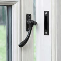 The Reversible Simplistic Black Iron Casement Fastener Displayed on a Classic White Painted Window Frame in an Open Position - Digital Illustration
