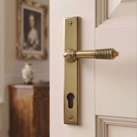The Ribbed Slimline Exterior Door Handle in Aged Brass on a Cream Coloured Door in a Country Home - Digital Illustration