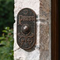 The "Ribbey Hall" Burnished Copper Brass Bell Push on a Stone Wall next to a Door - Digital Illustration The "Ribbey Hall" Burnished Copper Brass Bell Push on a Stone Wall next to a Door - Digital Illustration