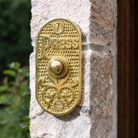 The "Ribbey Hall" Polished Brass Brass Bell Push Fitted next to a Door on a Stone Wall - Digital Illustration The "Ribbey Hall" Polished Brass Brass Bell Push Fitted next to a Door on a Stone Wall - Digital Illustration