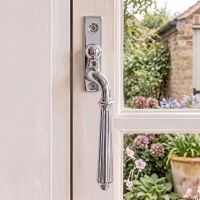 The Right Handed Polished Chrome Reeded Georgian Espagnolette Window Handle on a White Wooden Window Frame with Garden in the Background - Digital Illustration 