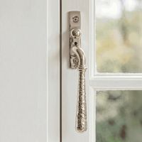 The Right Handed Polished Nickel Hammered Espag Window Handle Fixed on a Painted White Window Frame - Digital Illustration The Right Handed Polished Nickel Hammered Espag Window Handle Fixed on a Painted White Window Frame - Digital Illustration