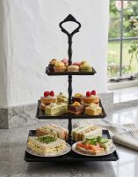 The “Riverhill Park” Black Three Tier Cake Stand In a White Coloured Country Cottage Displaying Cakes and Sandwiches for an Afternoon Tea - Digital Illustration
