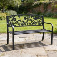 The Robins Iron & Steel Park Bench in Black in a Lush Green Garden with a Stone Patio - Digital Illustration