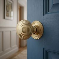 The Satin Brass "Beehive" Mortice & Rim Doorknob Set in a Home Hallway on a Blue Door - Digital Illustration The Satin Brass "Beehive" Mortice & Rim Doorknob Set in a Home Hallway on a Blue Door - Digital Illustration