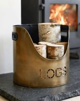 The Set of Two "LOGS" and "KINDLING" buckets in an Antique Brushed Gold Finish next to a Lit Log Burner Stove - Digital Illustration The Set of Two "LOGS" and "KINDLING" buckets in an Antique Brushed Gold Finish next to a Lit Log Burner Stove - Digital Illustration