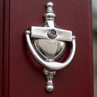 The Silver Small Victorian Urn Knockers on a Red Door Shown from a Low Angle  - Digital Illustration 