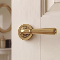 The Slender Classic Reeded Lever on Plain Rose Set in Aged Brass on a Cream Door in a Country Home - Digital Illustration