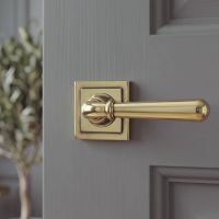 The Slender Classic Reeded Lever on Square Rose Set in Aged Brass on a Grey Door in a Contemporary Home - Digital Illustration