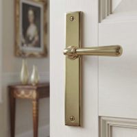 The Slimline Smooth Lever Espagnolette Door Latch in Aged Brass Fitted onto a White Door in a Sunny Period Home - Digital Illustration
