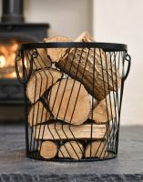 The Small Art Deco Wire Log Basket in Front of a Traditional Log Burner Stove - Digital Illustration The Small Art Deco Wire Log Basket in Front of a Traditional Log Burner Stove - Digital Illustration