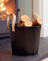 The Small Black Contemporary Dotted Log Basket with some Logs inside next to a Lit Log Burner Stove - Digital Illustration The Small Black Contemporary Dotted Log Basket with some Logs inside next to a Lit Log Burner Stove - Digital Illustration